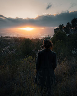 Rear view of woman looking at sunset