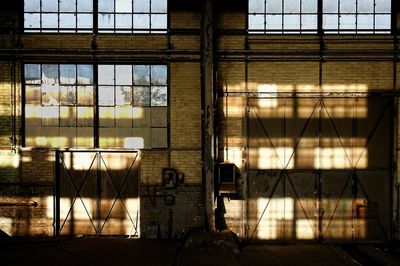 Interior of abandoned building windows illuminated by evening sunlight 