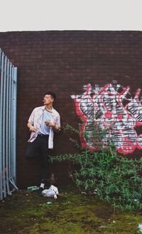 Full length of man standing against wall