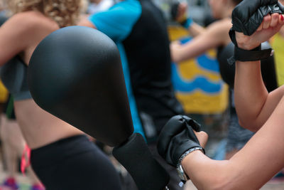 Midsection of woman wearing boxing gloves hitting speed bag