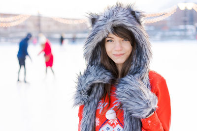 Portrait cute young woman in shaggy hat with ears looks at camera and smiles