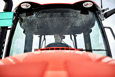 Farmer driving tractor at farm