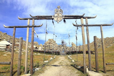 Cross amidst buildings against sky