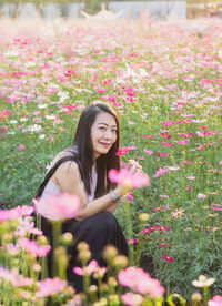 Portrait of young woman standing amidst plants