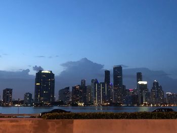 Illuminated buildings in city against sky