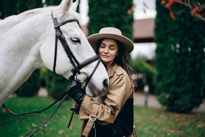 Rear view of woman with horse in park