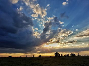 Scenic view of field against sky at sunset