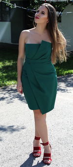 Young woman looking away while standing on road