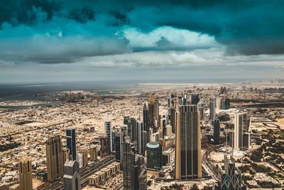 Aerial view of cityscape against cloudy sky