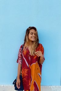 Portrait of young woman standing against sky