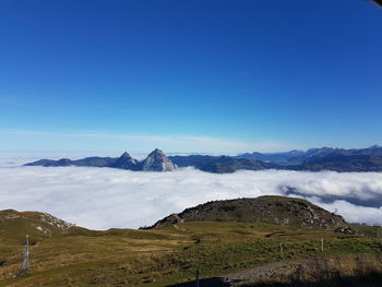 Scenic view of snowcapped mountains against blue sky