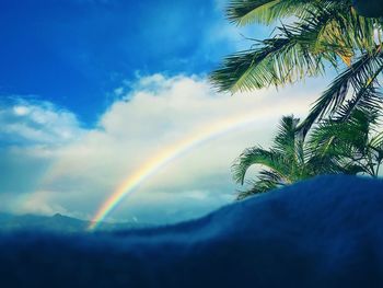 Scenic view of rainbow against blue sky