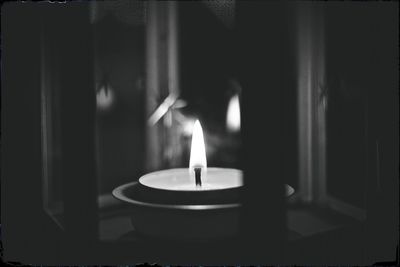 Close-up of lit candle in dark room