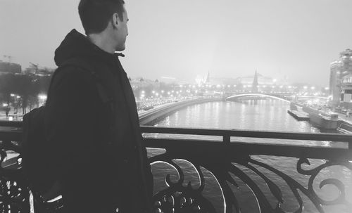 Man standing on bridge in city