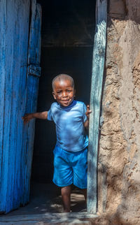 Portrait of boy standing against wall