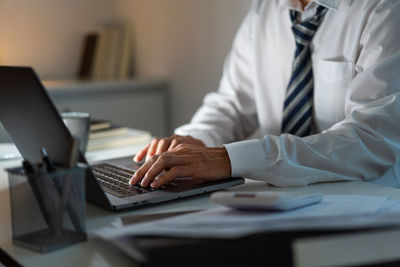 Midsection of businessman working at office