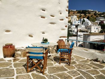 Chairs and table in town against buildings in city