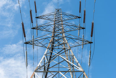 Low angle view of electricity pylon against sky