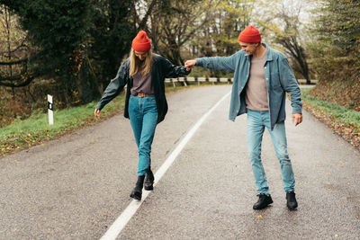 Rear view of man walking on road