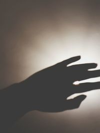 Close-up of silhouette hand against sky