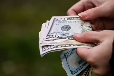 Close-up of hand holding paper outdoors