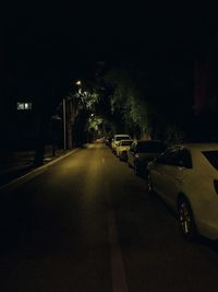 Cars on illuminated street at night