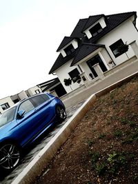 Cars on road by buildings against sky