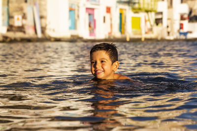 Smiling boy swimming in sea