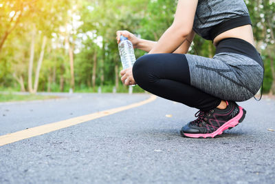 Woman squatting on road