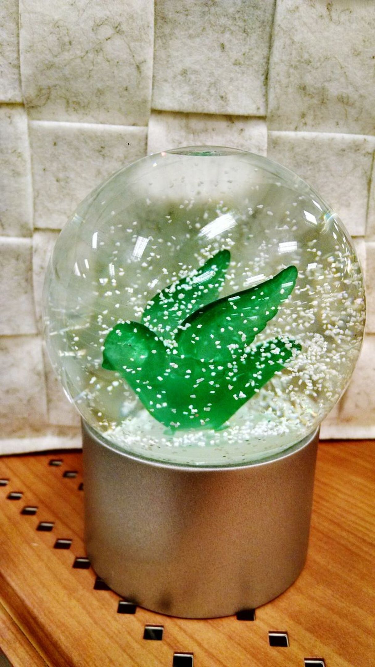 Green bird snow globe