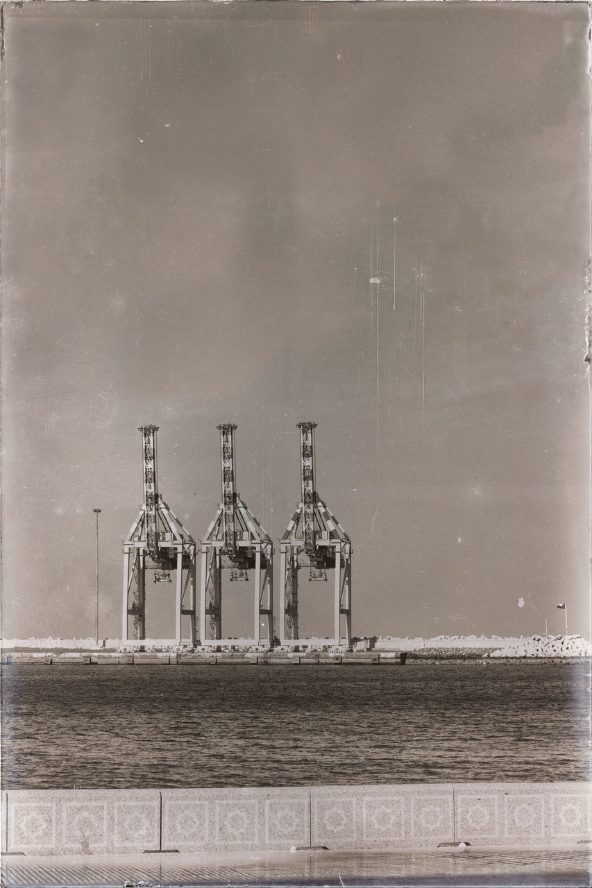 DIGITAL COMPOSITE IMAGE OF GLASS BUILDING AGAINST SEA