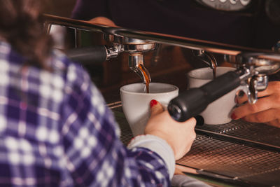 Midsection of woman pouring coffee in cup