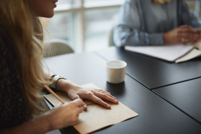 Woman taking notes during meeting