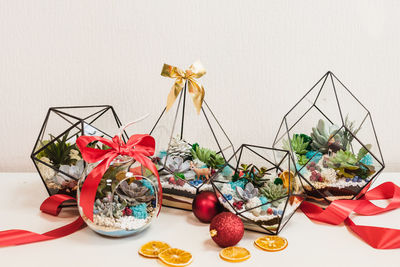 Multi colored christmas decorations on table against white background