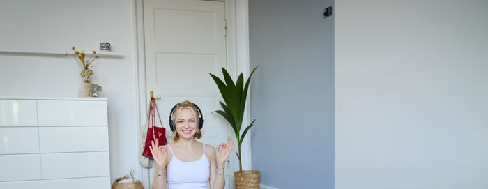 Portrait of young woman sitting on sofa at home