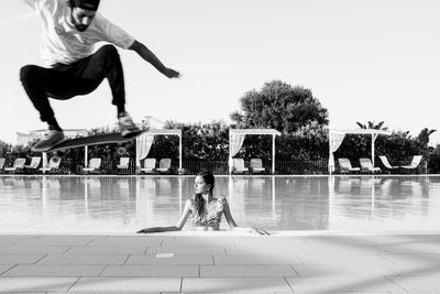 Young woman jumping in swimming pool