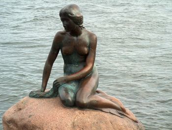 Rear view of man sitting on pier