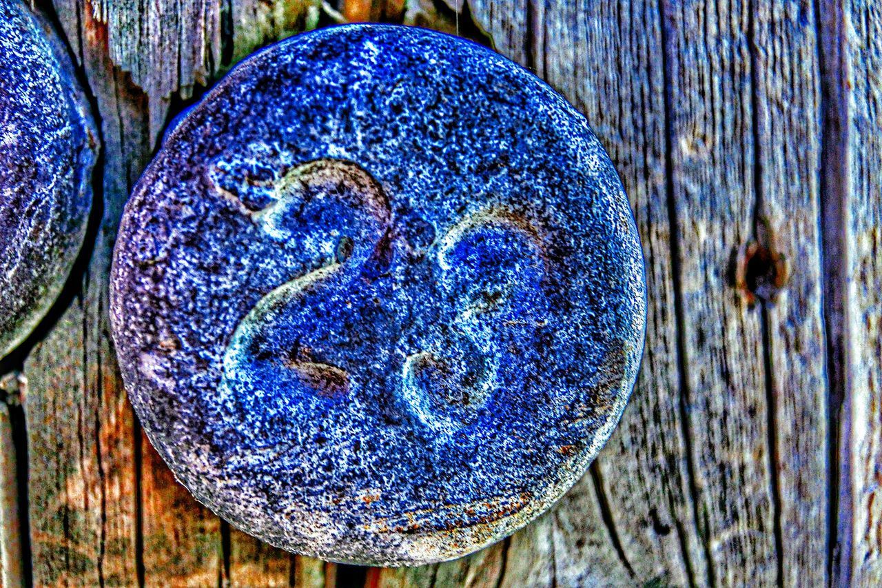 CLOSE-UP OF OLD METALLIC STRUCTURE ON WOOD