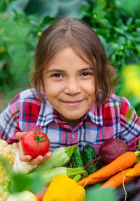 Portrait of smiling young woman with vegetables