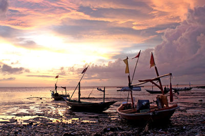 Boats moored on sea against sky during sunset