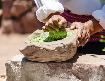 Midsection of person grinding spice in mortar