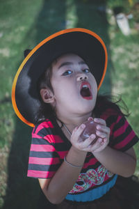 Portrait of girl wearing witch hat holding crystal ball