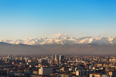 Aerial view of cityscape against clear blue sky