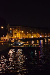 Illuminated buildings by sea at night