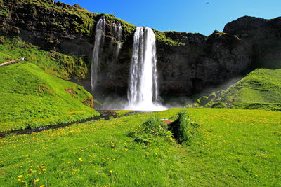 Scenic view of waterfall against sky