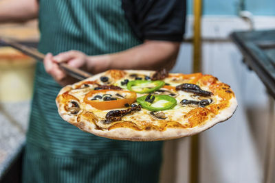 Close-up of man holding pizza