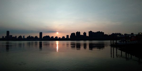 Scenic view of silhouette buildings against sky during sunset