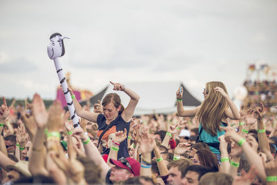 Group of people at music concert against sky