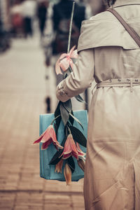 Rear view of girl holding umbrella walking on footpath