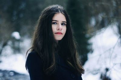 Portrait of young woman standing in snow